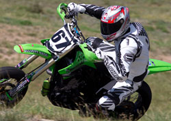 Adam Nicolson competing on a green motor bike