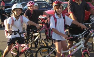 Three primary school age girls on bicycles